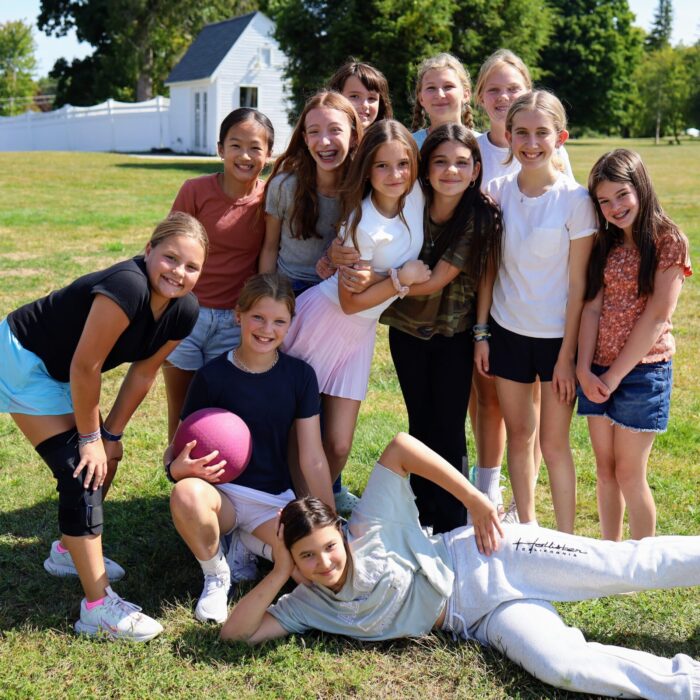 Group of sixth grade girls standing on the lawn.